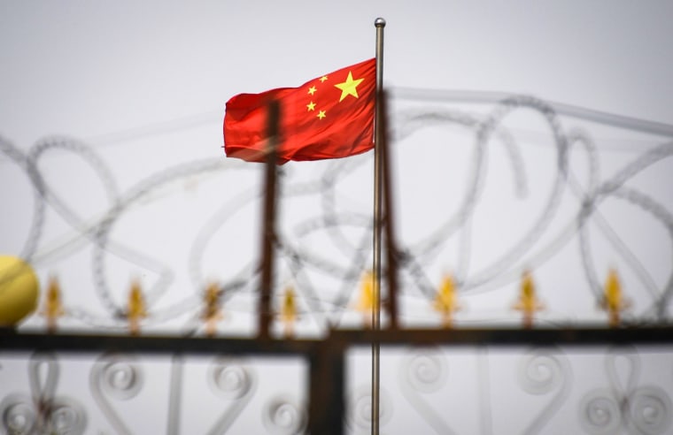 The Chinese flag behind razor wire at a housing compound in Yangisar, south of Kashgar, in China's western Xinjiang region on June 4, 2019.