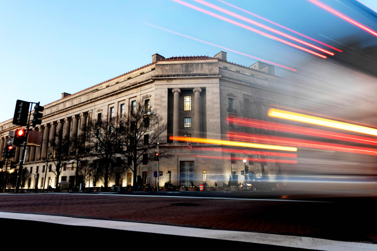 A vehicle drives past the Department of Justice building in Washington on Feb. 9, 2022.