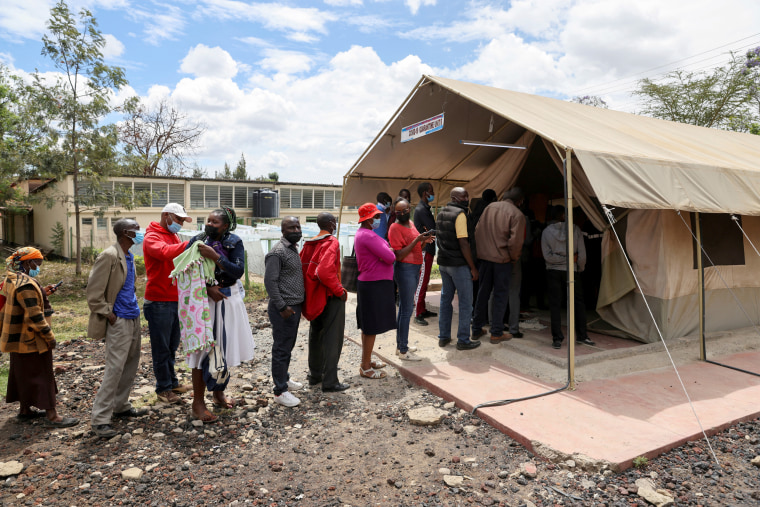 FILE PHOTO: People stand in line to receive COVID-19 vaccine in Narok, Kenya
