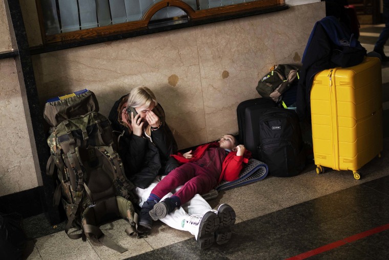 A woman with her daughter waits for a train as they try to leave Kyiv, Ukraine on Thursday, Feb. 24.