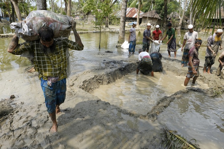 Villagers make a dam with mud in plastic bags to protect their only road in Pratap Nagar, that lies in the Shyamnagar region, in Satkhira, Bangladesh on Oct. 5, 2021.