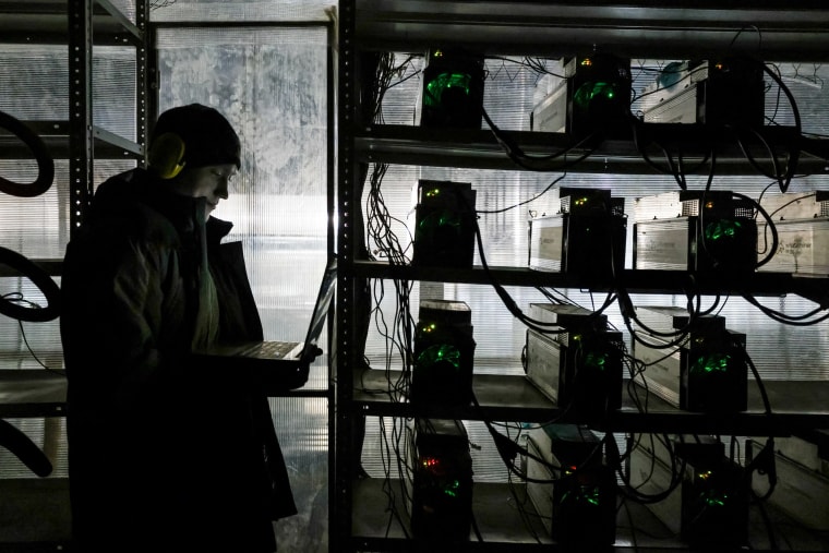A support engineer tends to server room equipment at the cryptocurrency mining company, BitRiver, in Bratsk, Russia on January 14, 2020.