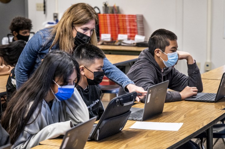 A substitute teacher helps a student in a 7th grade math class at Vista View Middle School in Huntington Beach, Calif., on Jan. 20, 2022.