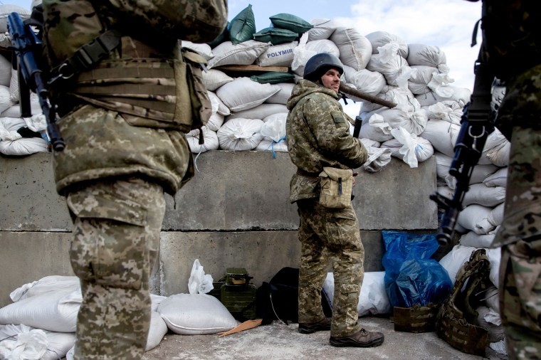 Ukrainian service members are seen at a check point in Zhytomyr