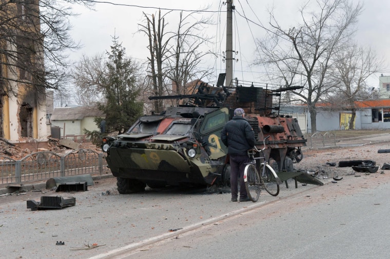 A man looks at a destroyed Ukrainian armored personnel carrier in Kharkiv, Ukraine, on Feb. 28, 2022.