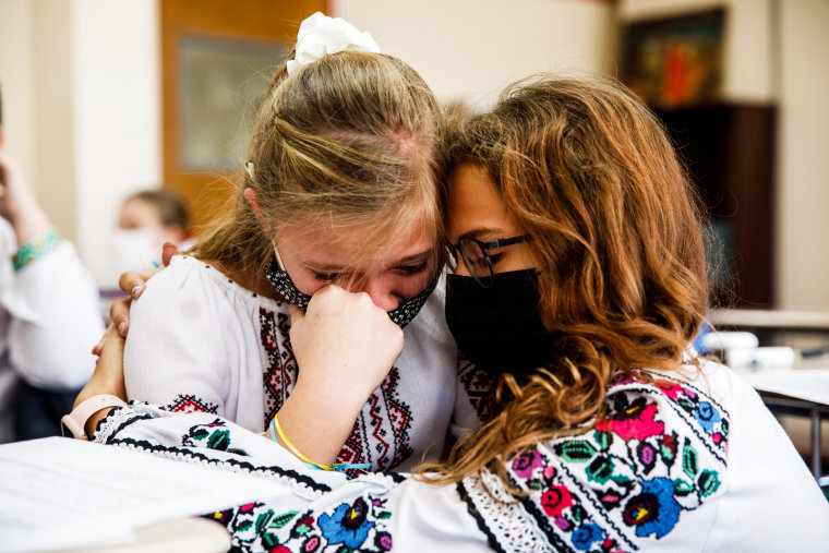 Anastasia Korolyk, right, hugs her friend and classmate Yulya Holiyat who started crying after she talked about the crisis in Ukraine at Self-Reliance School of Ukrainian Studies in New York on Feb. 26, 2022.