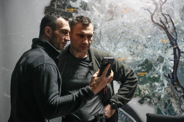 Vitali Klitschko, Kyiv Mayor and former heavyweight champion, right, and his brother Wladimir Klitschko, a Ukrainian former professional boxer look at a smart phone at City Hall in Kyiv, Ukraine, on Feb. 27, 2022.