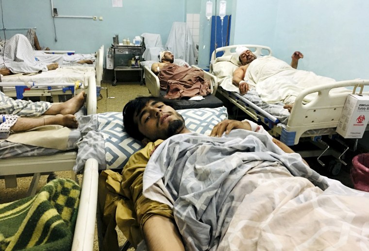 Wounded Afghans lie in a hospital after a deadly explosions outside the airport in Kabul, Afghanistan on Aug. 26, 2021.