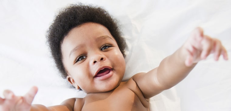 African American baby boy laying on bed