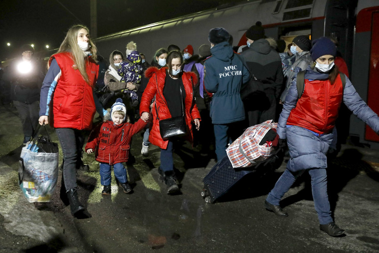 Personas de las regiones de Donetsk y Lugansk, el territorio controlado por los gobiernos separatistas prorrusos en el este de Ucrania, caminan desde un tren para ser llevados a residencias temporales el 20 de febrero de 2022.