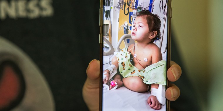 Cassandra Wesley, an enrolled member of the Yakama Nation, holds up a photo she took of her daughter Bonnie while in strict isolation at Seattle Children’s Hospital.