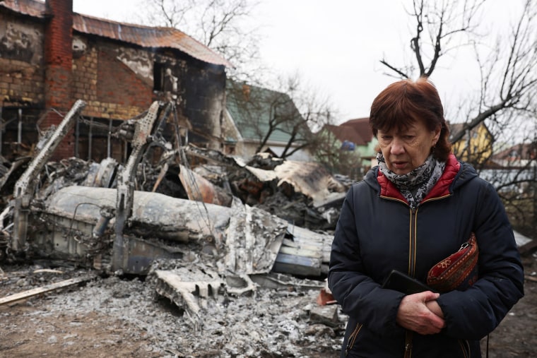 Una mujer camina alrededor de los restos de un avión no identificado que se estrelló contra una casa en una zona residencial, después de que Rusia lanzara una operación militar masiva contra Ucrania, en Kiev, Ucrania, el 25 de febrero de 2022.