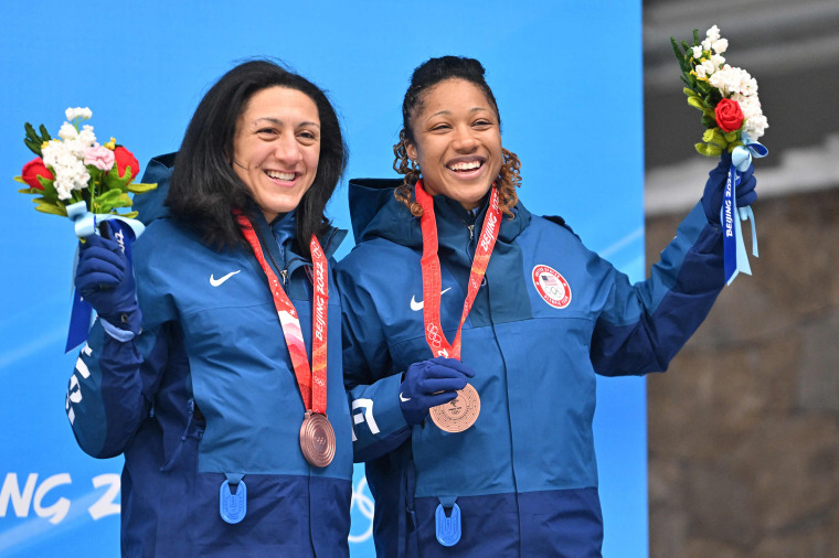 USA's Elana Meyers Taylor and Sylvia Hoffman celebrate on the podium with their bronze medals during the venue ceremony after the 2-woman bobsleigh event at the Yanqing National Sliding Centre during the Beijing 2022 Winter Olympic Games in Yanqing on Feb