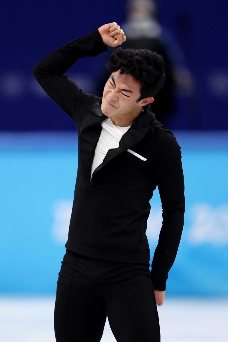 Nathan Chen pumps his fist and grimaces while still standing on the ice.