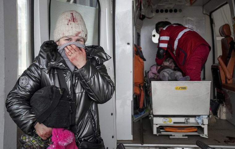 Una mujer reacciona mientras los paramédicos realizan RCP a una niña que resultó herida durante un bombardeo, en el hospital de la ciudad de Mariupol, en el este de Ucrania, el domingo 27 de febrero de 2022.