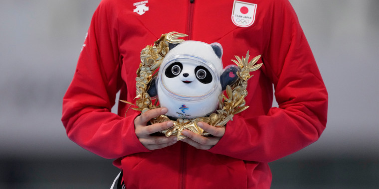 A stuffed mascot Bing Dwen Dwen stands in for a medal.