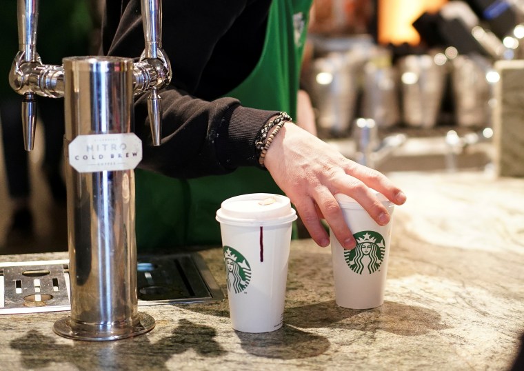 A barista serves beverages in single use cups inside a Starbucks in London