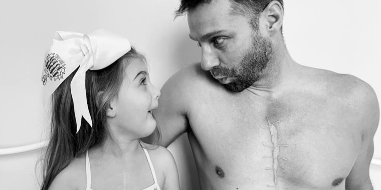 Everly Backe, 4, shares a happy moment with her dad, Matt Backe. He now sports a tattoo on his chest that looks like her scar from open-heart surgeries.  