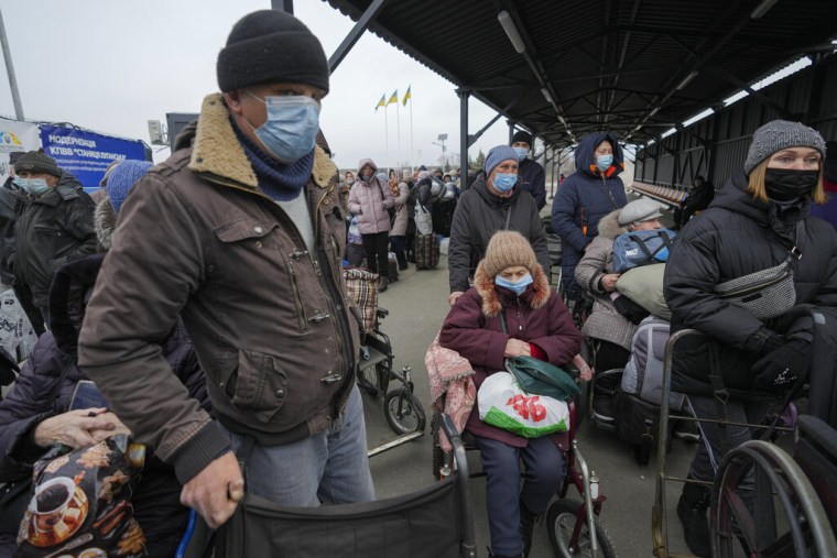 Gente espera para cruzar al territorio controlado por los separatistas prorrusos en Stanytsia Luhanska, el único punto de cruce abierto diariamente, en la región de Luhansk, en el este de Ucrania, el martes 22 de febrero de 2022.