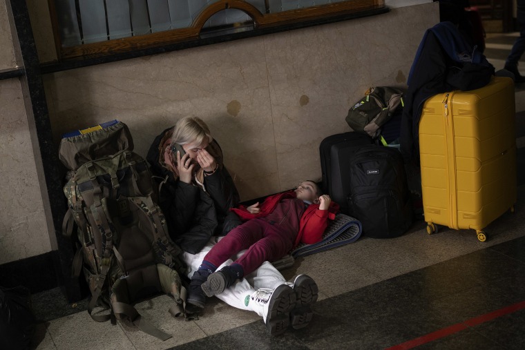 Una mujer espera junto a su su hija para tomar un tren para huir de la ciudad de Kiev, Ucrania, el jueves 24 de febrero de 2022.