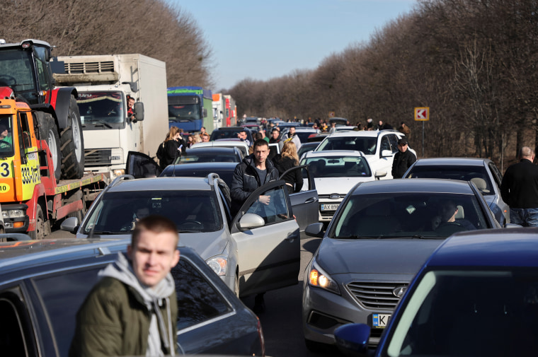 People wait in a traffic jam as they leave the city of Kharkiv