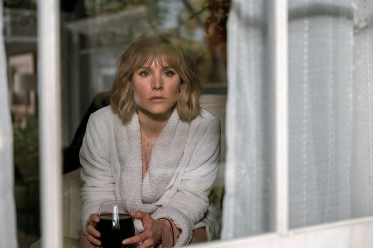 Kristen Bell as Anna, who holds a glass of wine that's actually grape juice, peers outside her window in episode 101 of "The Woman in the House Across the Street From the Girl in the Window."