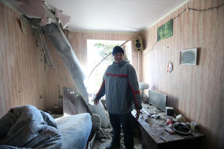 Un hombre mira su apartamento luego de recibir un poyectil en Jarkóv, Ucrania.
