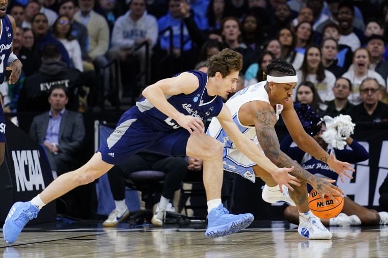 St. Peter's Doug Edert, left, and North Carolina's Armando Bacot chase a loose ball during the first half of a college basketball game in the Elite 8 round of the NCAA tournament, Sunday, March 27, 2022, in Philadelphia. (AP Photo/Matt Rourke)