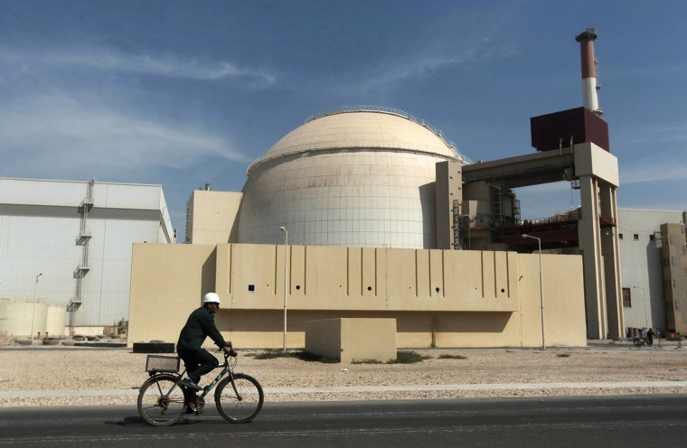 A worker rides a bicycle in front of the reactor building of the Bushehr nuclear power plant outside the southern city of Bushehr, Iran, on Oct. 26, 2010.