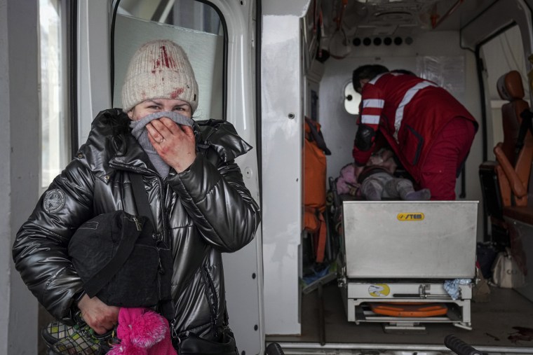 A woman reacts as paramedics perform CPR on a girl who was injured during shelling, at city hospital of Mariupol, eastern Ukraine, on Sunday. The girl did not survive.