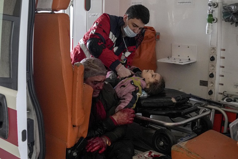 Oleksandr Konovalov, an ambulance paramedic, performs CPR on a girl injured by the shelling in a residential area as her dad sits, left, after arriving at the city hospital of Mariupol on Sunday.