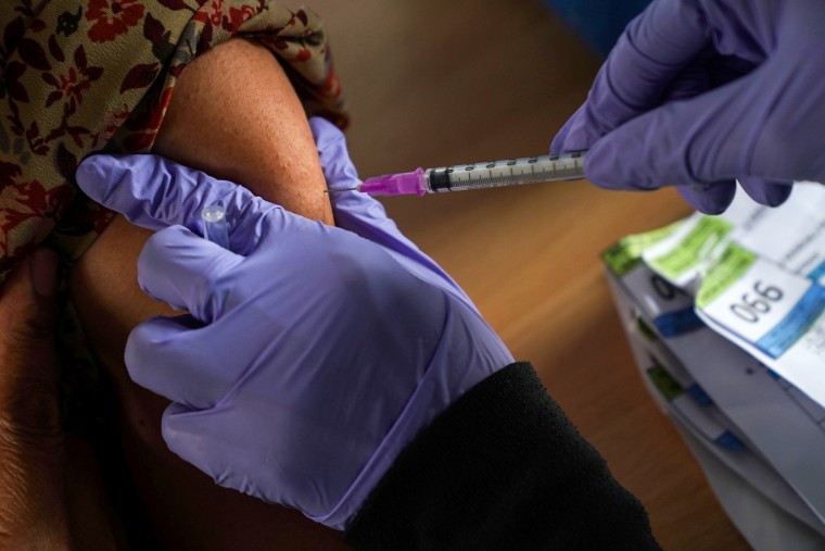 A healthcare worker administers a dose of the Pfizer-BioNTech Covid-19 vaccine at a health center in Jakarta, Indonesia, on Jan. 13, 2022.