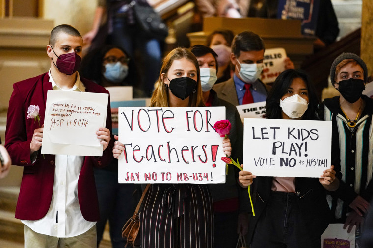 Protesters carry signs at a rally held in opposition to bills being considered at the Statehouse in Indianapolis on Feb. 16, 2022.