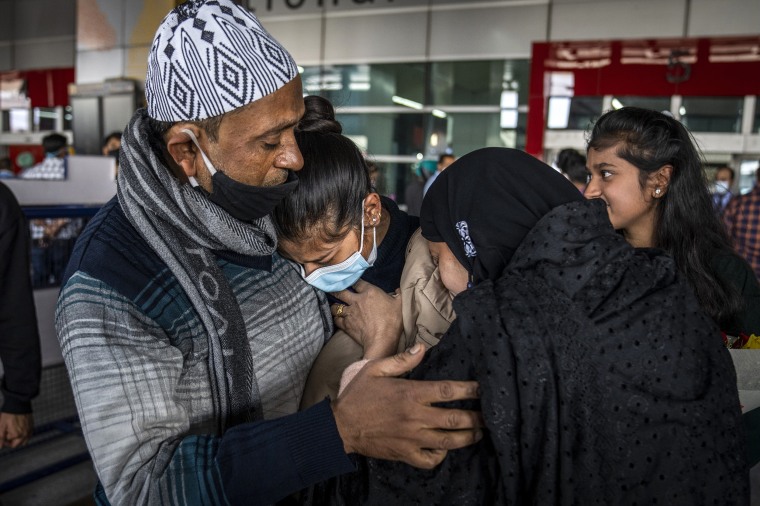 Image: Parents hug Iqra Praveen, center, an Indian student studying in Ukraine who fled the conflict, after she arrived at Indira Gandhi International Airport in New Delhi on March 2, 2022.