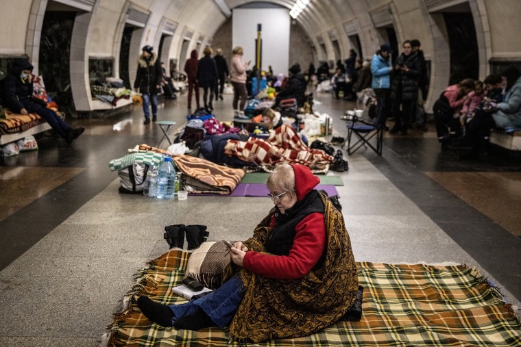Image: A woman uses her mobile phone as she takes shelter in the Dorohozhychi subway station which has has been turned into a bomb shelter on March 2, 2022 in Kyiv, Ukraine.