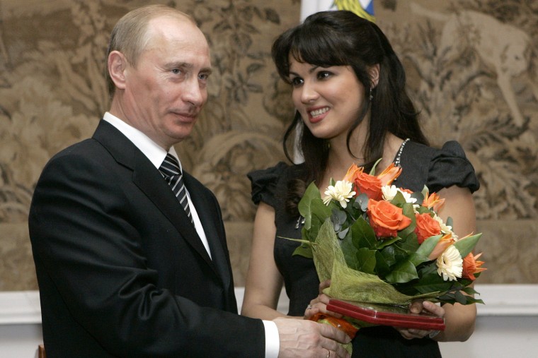 Russian President Vladimir Putin, left, congratulates Russian opera singer Anna Netrebko after awarding her with the People's Artist of Russia honor in St. Petersburg, on Feb. 27, 2008.