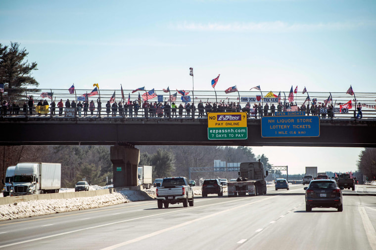 People on an overpass cheer on the convoy near Portsmouth, N.H., on March 2, 2022.
