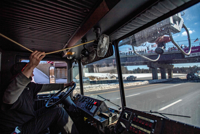 Cody Moores blows his horn as he drives past onlookers cheering on the convoy in Kennebunkport, Maine, on March 2, 2020.