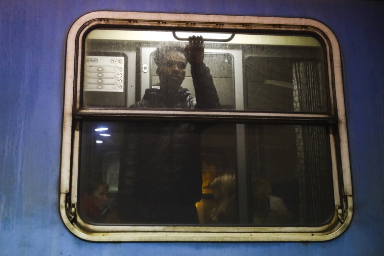 A non-Ukrainian passenger waits on a train platform in Poland