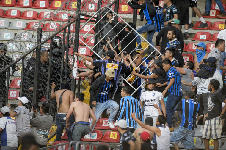 Fans clash during a Mexican soccer league match between the host Queretaro and Atlas from Guadalajara, at the Corregidora stadium, in Queretaro, Mexico, Saturday, March 5, 2022.