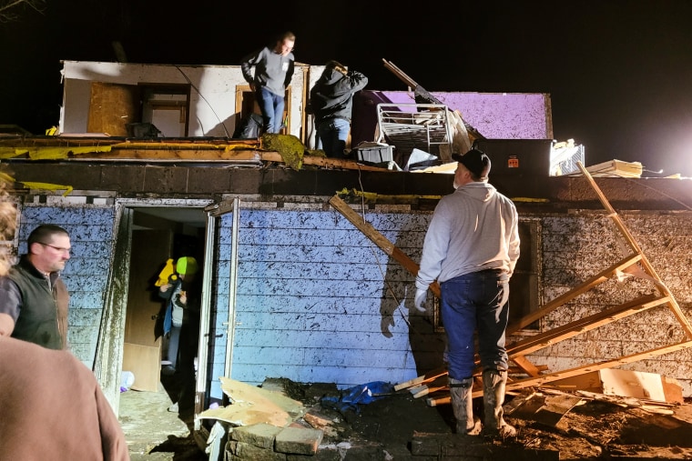 People removing belongings from home after a tornado in Winterset, Iowa, on March 5, 2022.