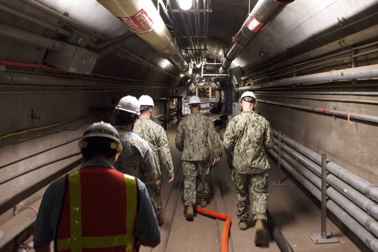Rear Adm. John Korka, center, leads Navy and civilian water quality recovery experts through the tunnels of the Red Hill Bulk Fuel Storage Facility, near Pearl Harbor, Hawaii, on Dec. 23, 2021.