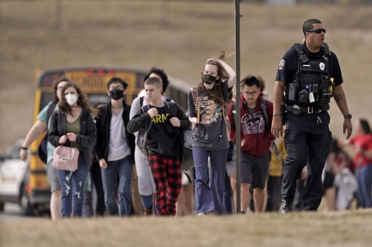 Students from Olathe East High School are led to a staging area