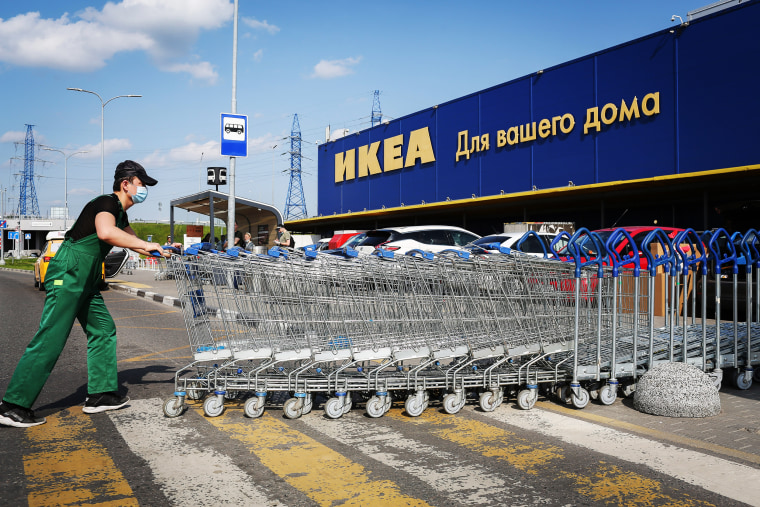 Image : Un employé empile des caddies devant un magasin Ikea à Moscou le 9 juin 2020.