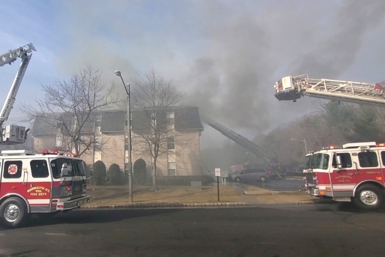 Firefighters work to put out a residential building fire in South Brunswick, NJ, on March 7, 2022.