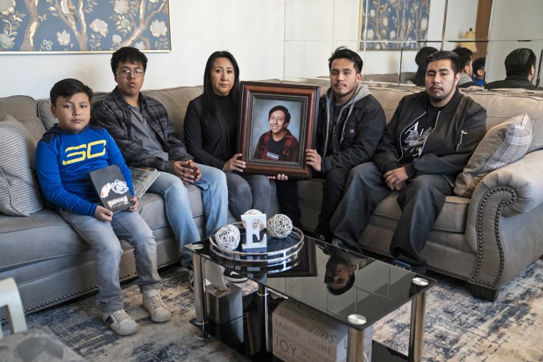 Eddie, Brandon, Saraid, Christopher and Oscar Arizaga Hernandez with a photo of Elliott at their new home in Adamsville, Ala.