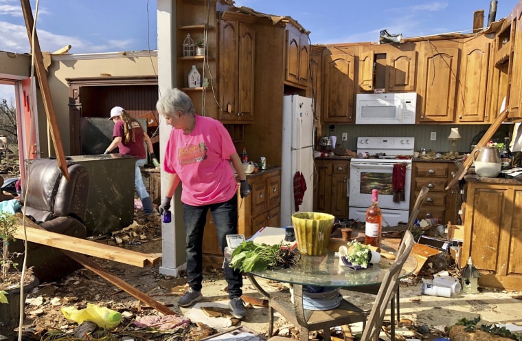 Patti Herring sorts through the remains of her home in Fultondale, Ala., on Jan. 26, 2021.