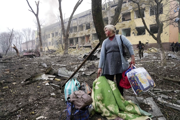 A woman walks outside the damaged by shelling maternity hospital in Mariupol, Ukraine, Wednesday, March 9.