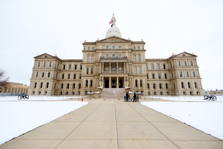 Police patrol the grounds outside the Michigan state capitol building on January 20, 2021 in Lansing.