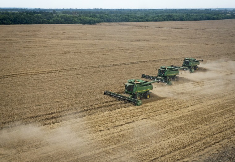 Immagine: le mietitrebbie attraversano un campo di grano durante un raccolto estivo nella regione di Poltava, in Ucraina, il 18 luglio 2014.
